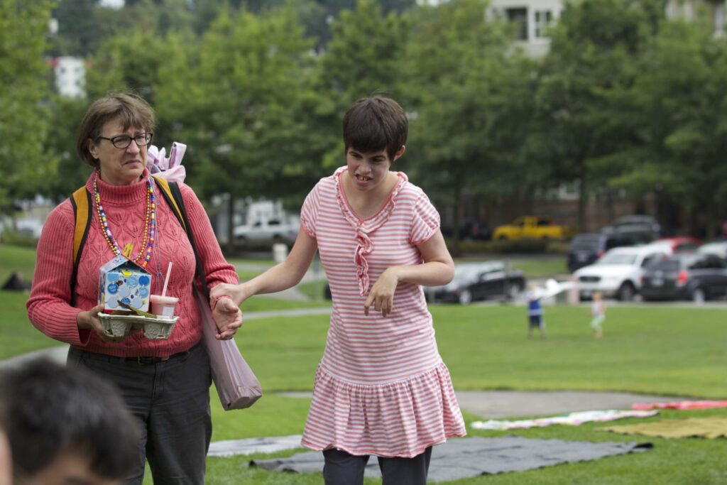 mother and adult daughter walking together holding hands